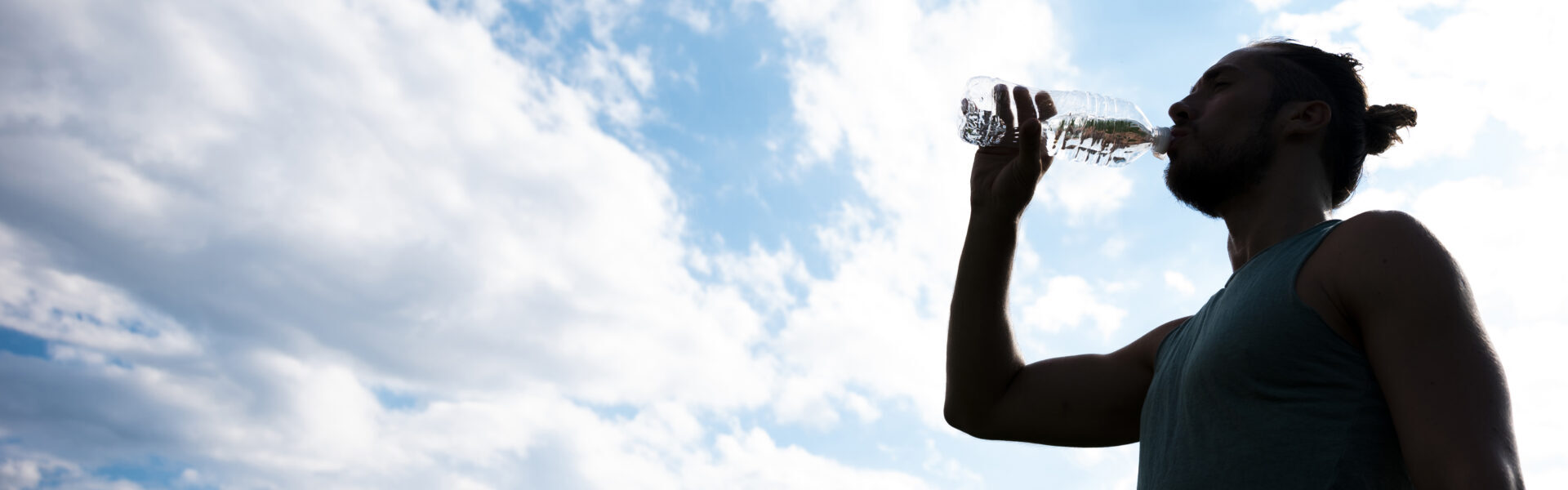 Mann trinkt aus Wasserflasche.