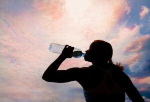 Frau trinkt aus Wasserflasche.