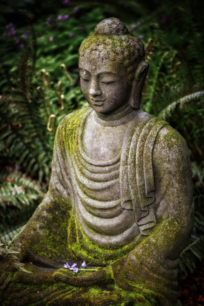 Stimmungsbild: Buddha Statue mit Moos bedeckt.