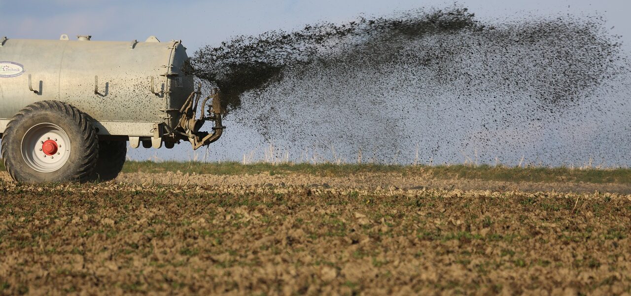 Landwirtschaftsfahrzeug verstreut Pestizide und Dünger auf Feld.