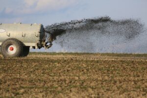 Landwirtschaftsfahrzeug verstreut Pestizide und Dünger auf Feld.