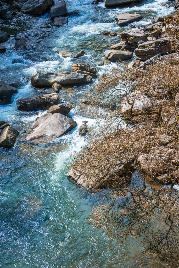 Stimmungsbild: Fluss fließt durch ein Gebirgspfad.