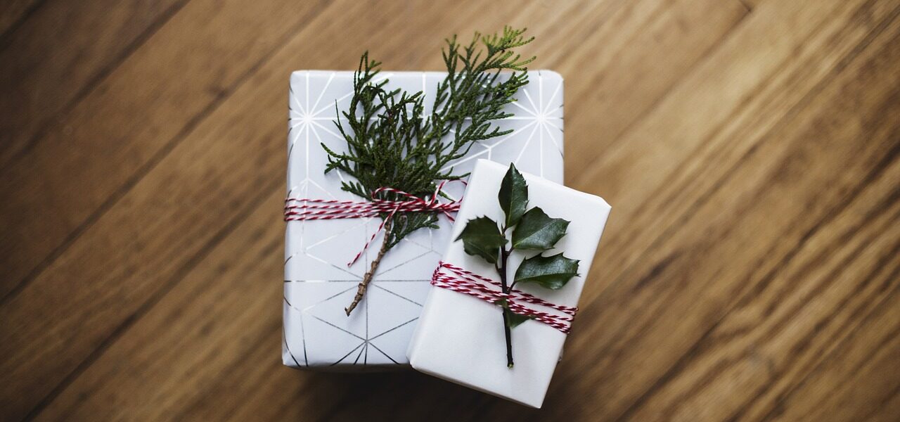 Zwei Weihnachtsgeschenke mit kleinen Zweigen dekoriert.